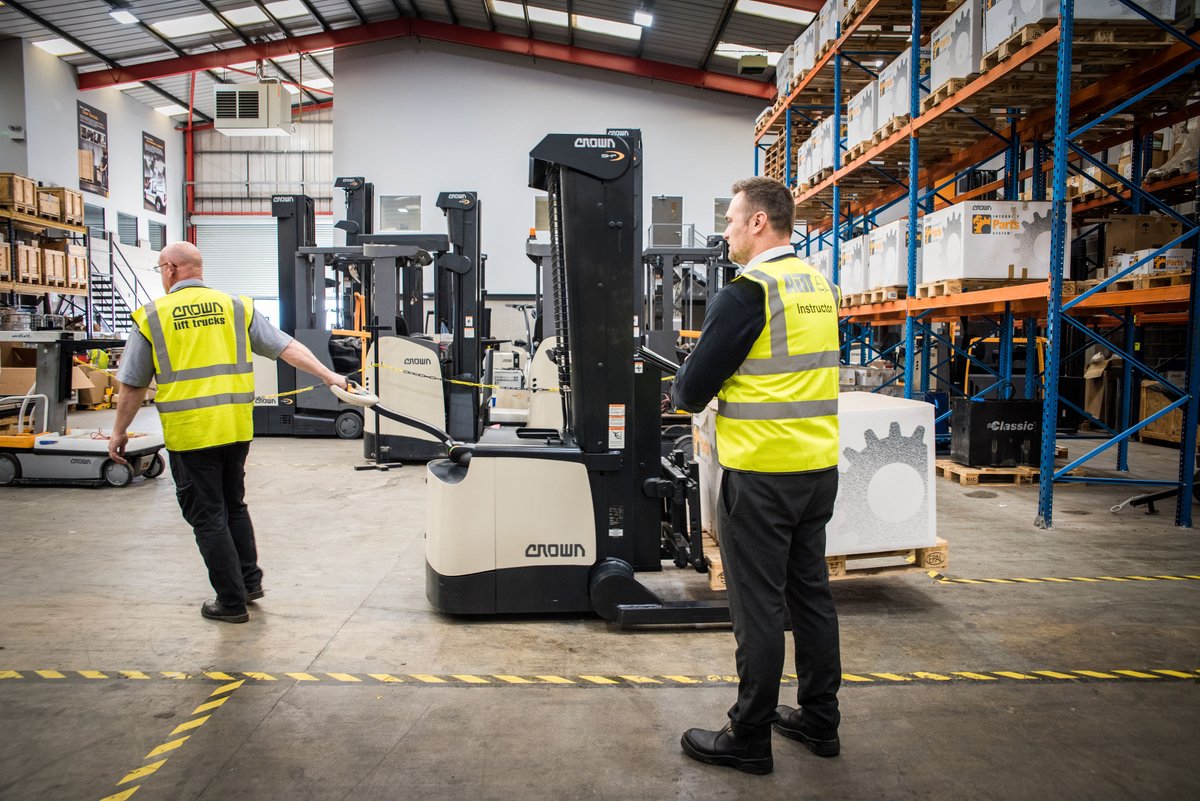 Two men from Crown Lift Trucks in their warehouse using our industrial lighting solution